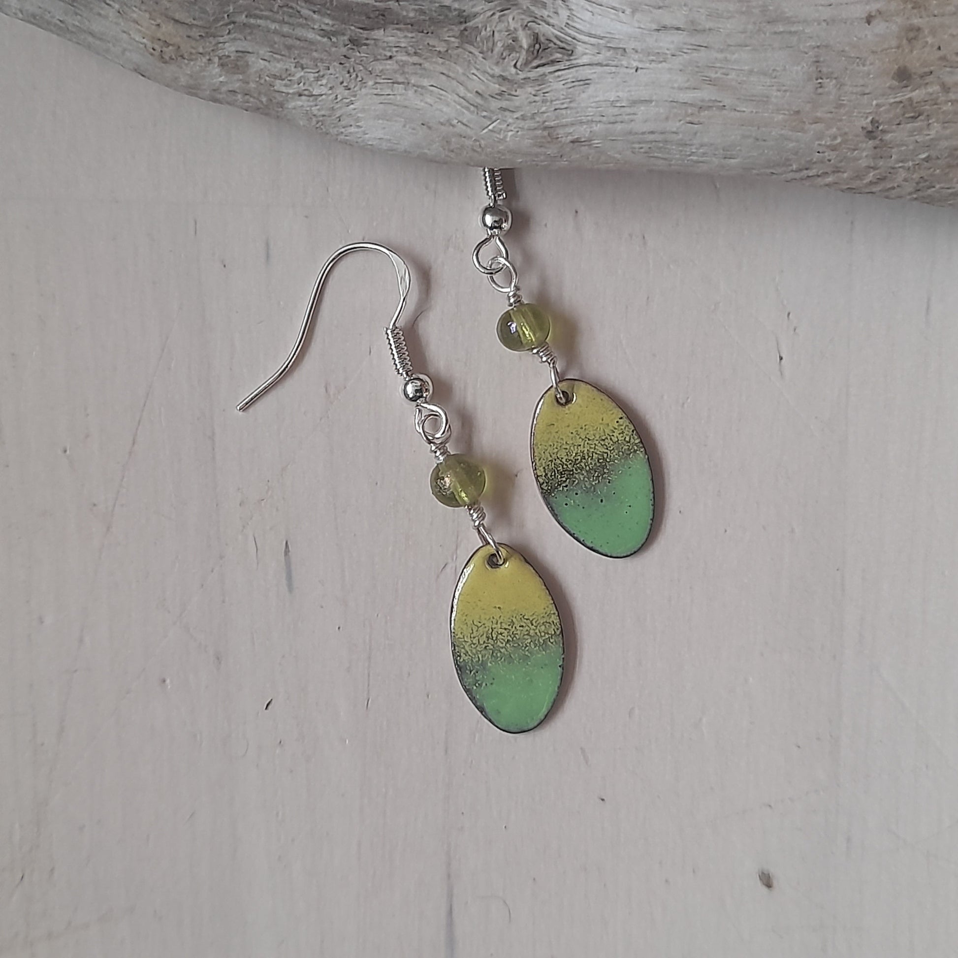 subtle yellow and green oval enamel earrings. Presented on silver wires with decorative glass bead 